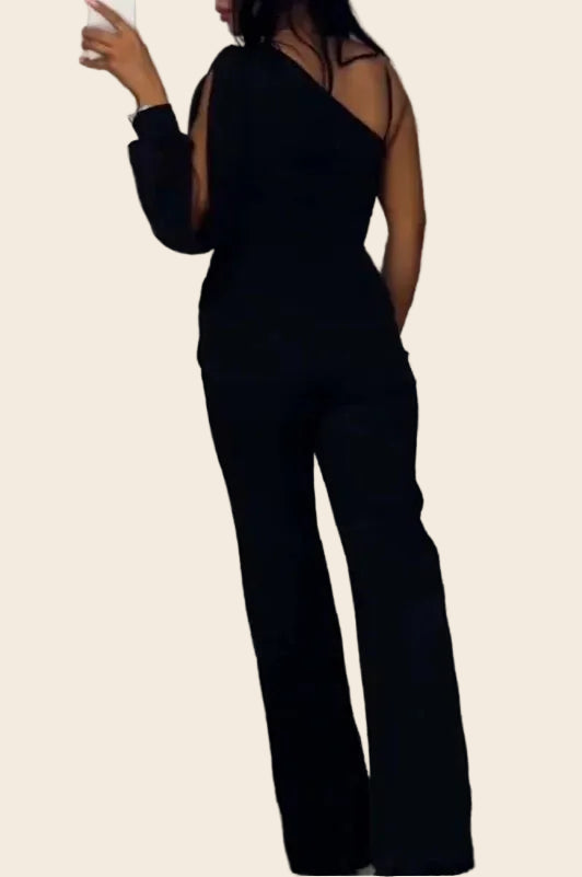 Combinaison noir épaule asymétrique vue de dos soulignant la coupe cintrée et l'élégance de l'épaule dénudée.