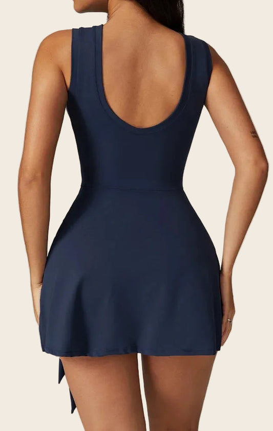 Combinaison short yoga jupe luxembourg bleu marine, large décolleté arrondi au dos soulignant la silhouette sportive.