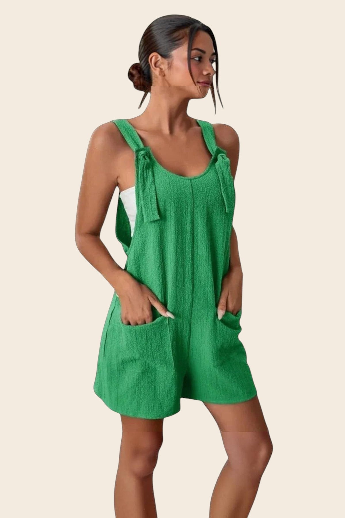 Combinaison short verte en polyester et élasthanne, avec liens sur les épaules et poches plaquées. Maison de la Combi.