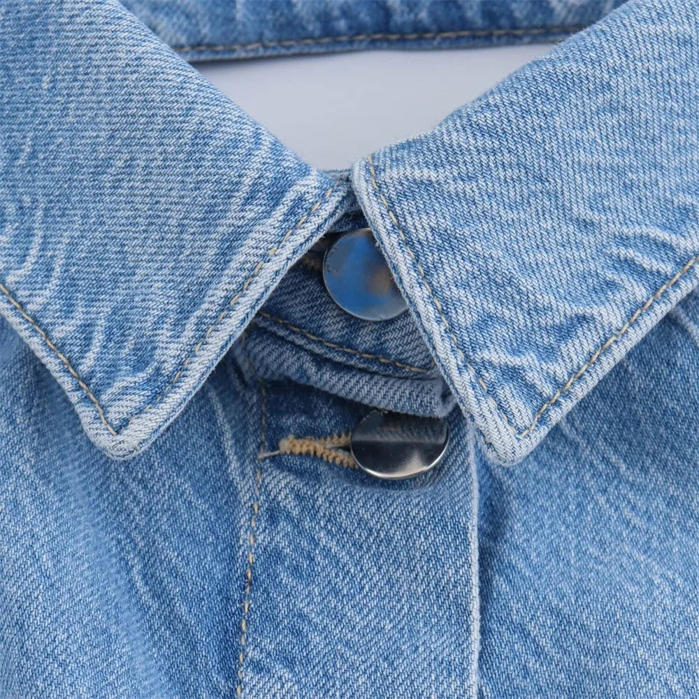 gros plan sur les boutons du col de la combinaison en jean bleu ciel