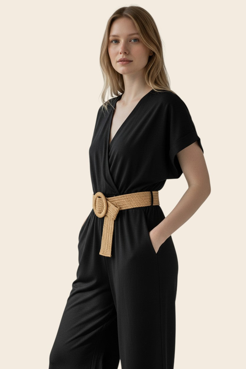 Combinaison pantalon noire femme maison de la combi avec col V croisé, manches courtes et ceinture tressée beige.
