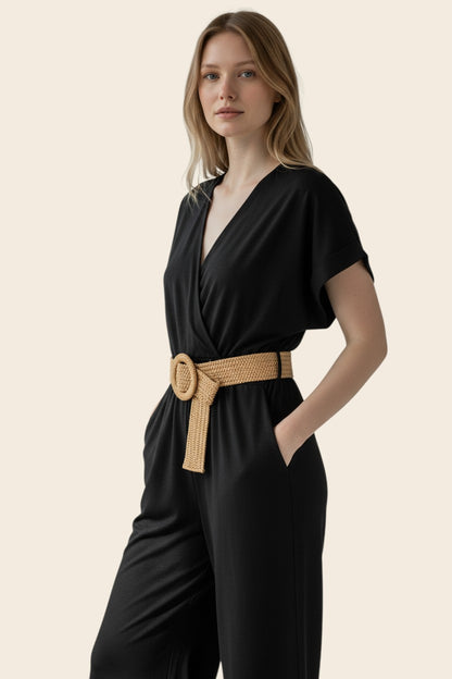 Combinaison pantalon noire femme maison de la combi avec col V croisé, manches courtes et ceinture tressée beige.