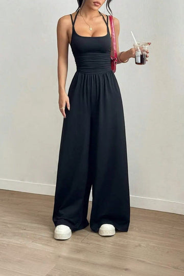 Combinaison noire La Esmeralda à bretelles fines, taille smockée et jambes larges en polyester et élasthanne.