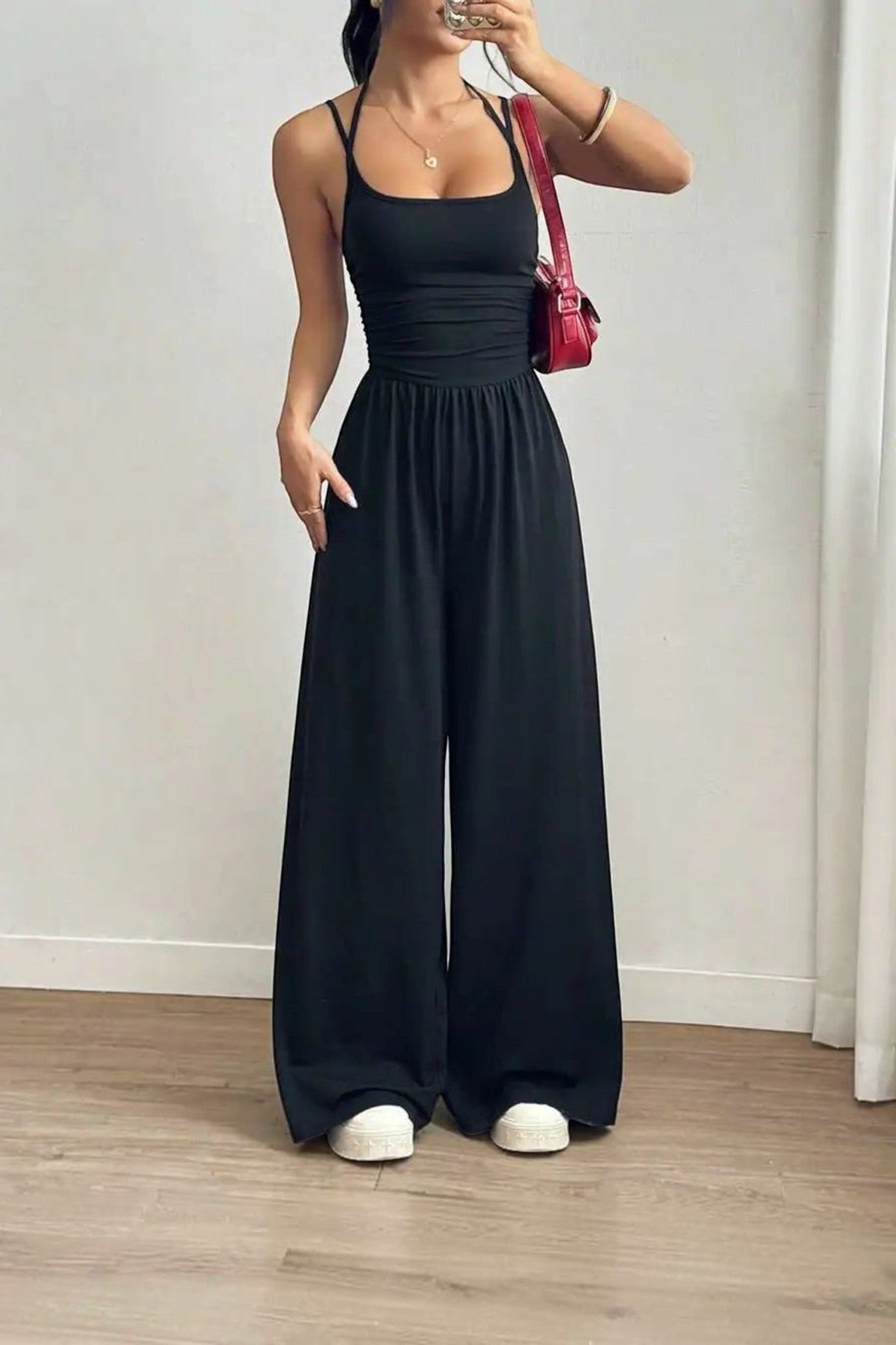 Combinaison noire La Esmeralda à bretelles fines, encolure carrée, taille smockée et jambes larges en polyester et élasthanne.