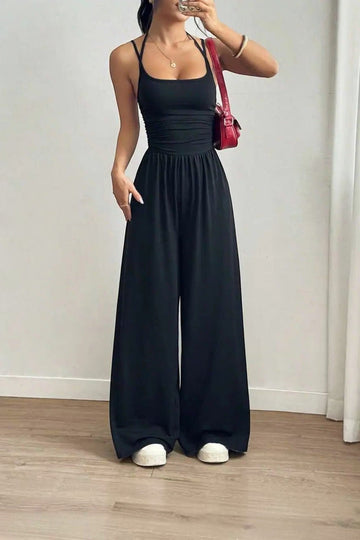 Combinaison noire La Esmeralda à bretelles fines, encolure carrée, taille smockée et jambes larges en polyester et élasthanne.