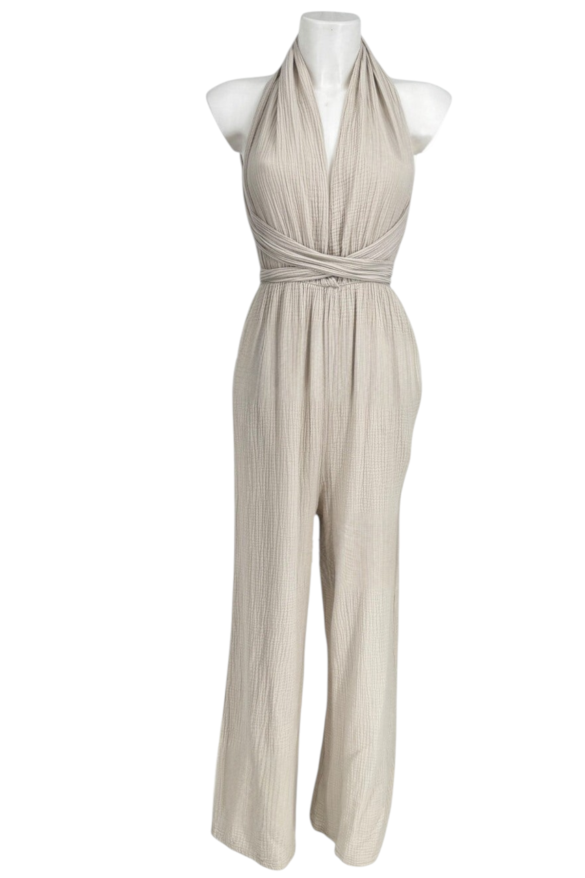 Femme portant une combinaison beige en gaze de coton, encolure nouée autour du cou, taille haute et jambes larges, vue de face