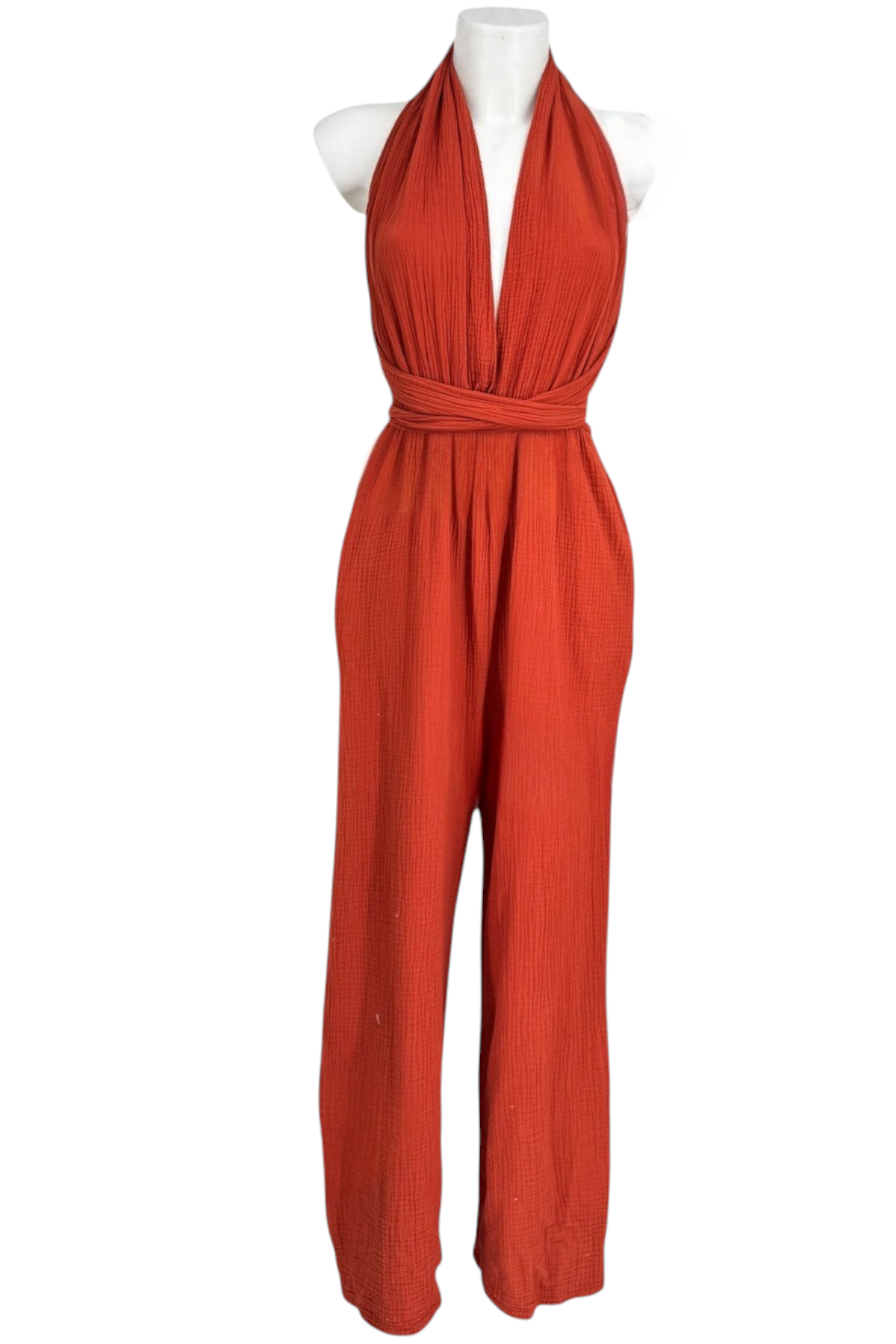 Femme portant une combinaison terracotta en gaze de coton, encolure nouée autour du cou, taille haute et jambes larges, vue de face