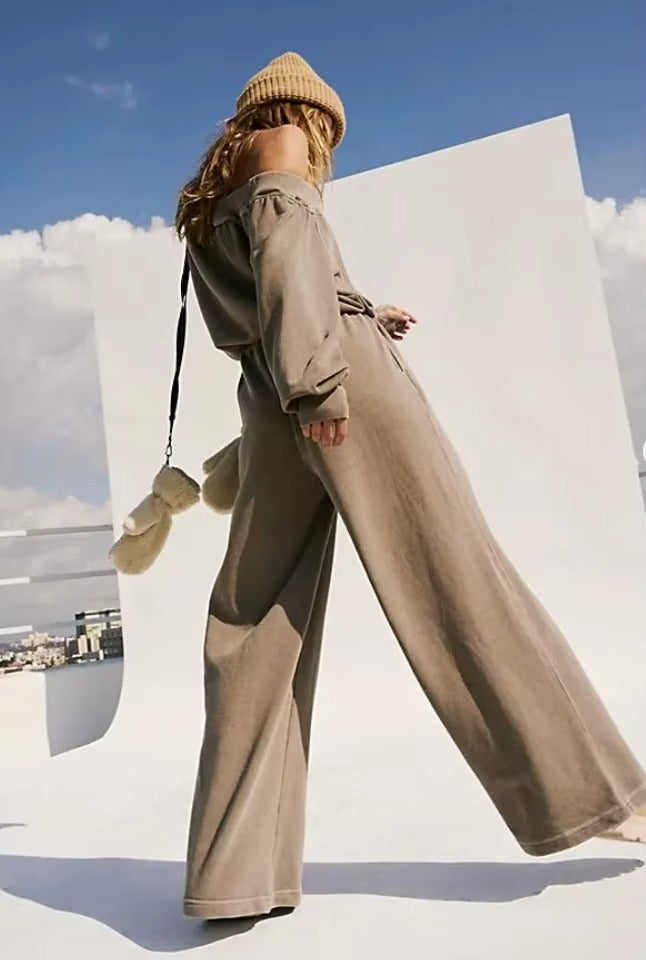 Une combinaison pour femme large, de couleur kaki , elle porte aussi un bonnet 