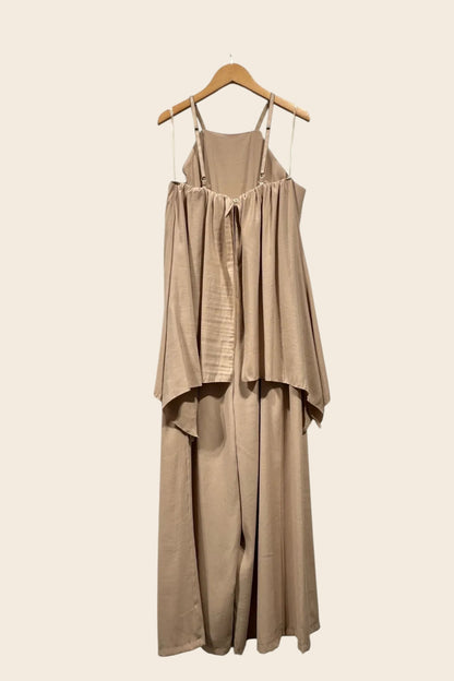 Combinaison fluide beige vue de dos sur cintre, bretelles fines ajustables réglables, dos froncé et buste évasé effet cape retombant sur un pantalon large palazzo