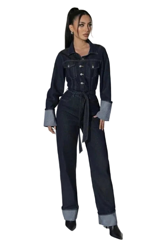 Combinaison Marais bleu, coupe ajustée en denim brut avec boutonnage frontal et revers aux poignets, portée avec des bottines noires.