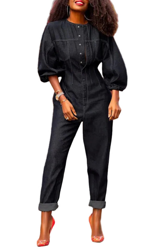 Combinaison jean noir Temple, coupe ajustée avec manches bouffantes et boutonnage frontal, portée avec des escarpins rouges.