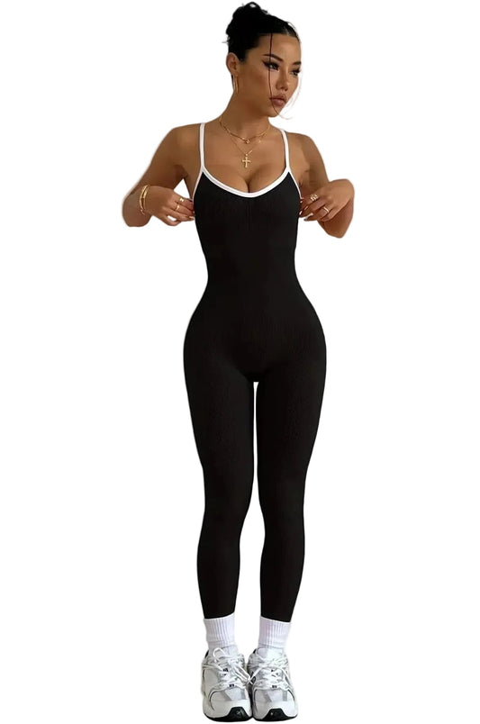 Combinaison legging sport noire avec liseré blanc portée de face soulignant une coupe ajustée.