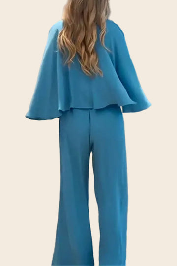 Combinaison bleu clair vue de dos montrant la coupe droite du pantalon large et le drapé des manches.

