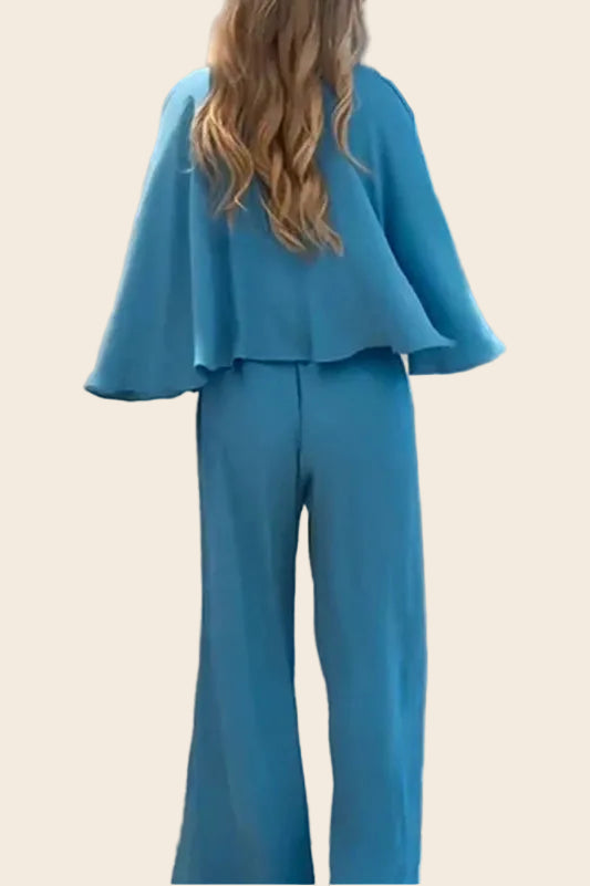 Combinaison bleu clair vue de dos montrant la coupe droite du pantalon large et le drapé des manches.

