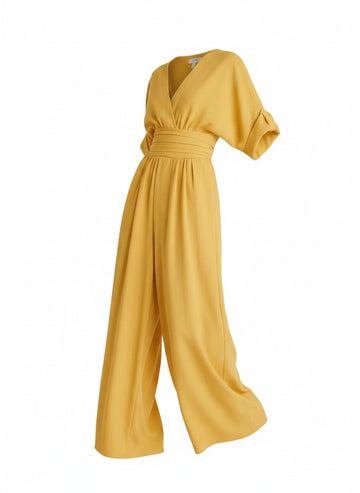 Vue de trois quarts de la combinaison pantalon jaune. Tissu fluide infroissable soulignant le mouvement majestueux de la jambe.