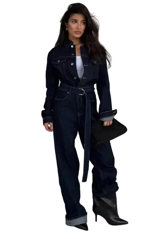 Combinaison pantalon jean La Odéon bleu marine, coupe large avec ceinture à boucle et revers aux chevilles, portée avec des bottines noires.