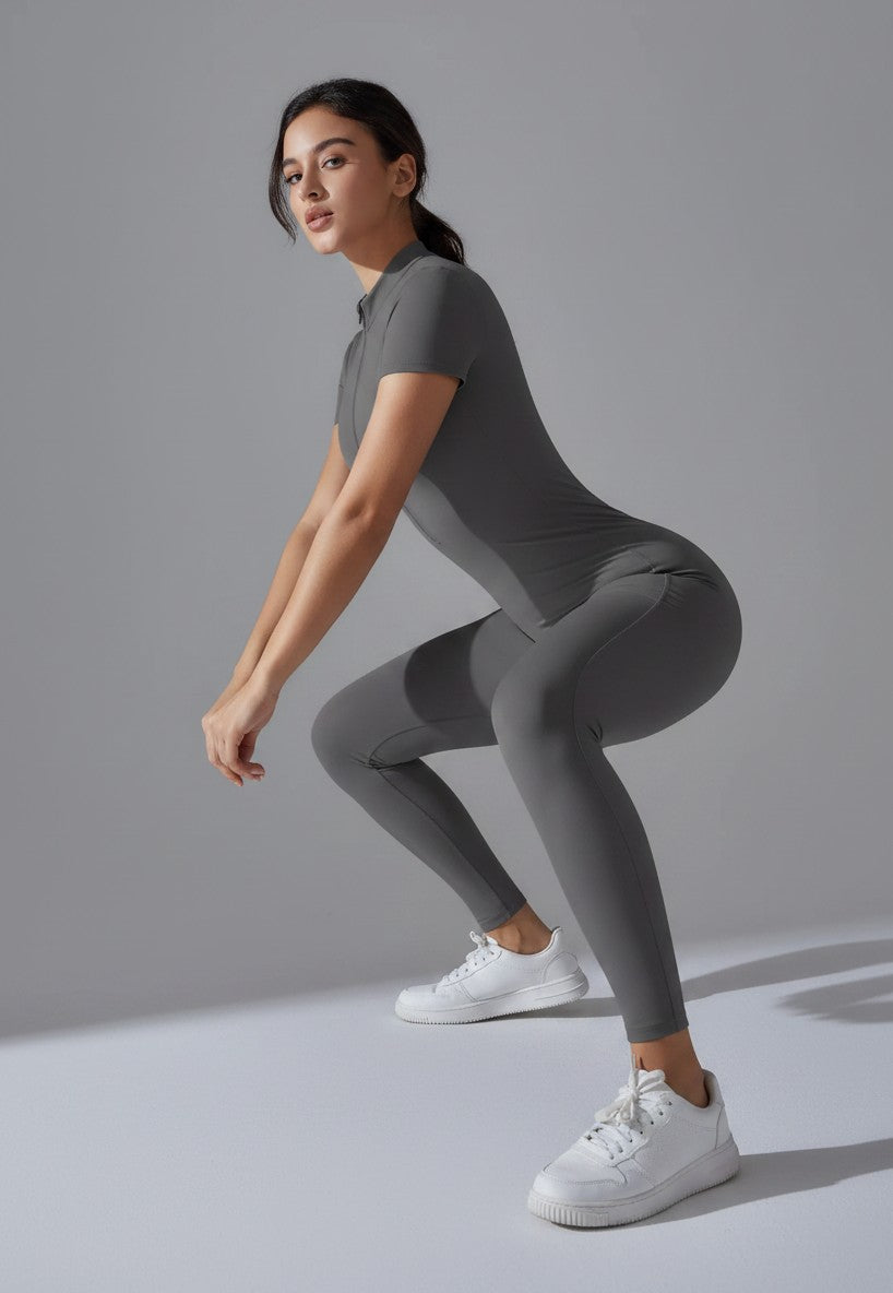 Combinaison de sport grise pour femme testée en posture d'étirement. Une opacité totale et une souplesse maximale du tissu.