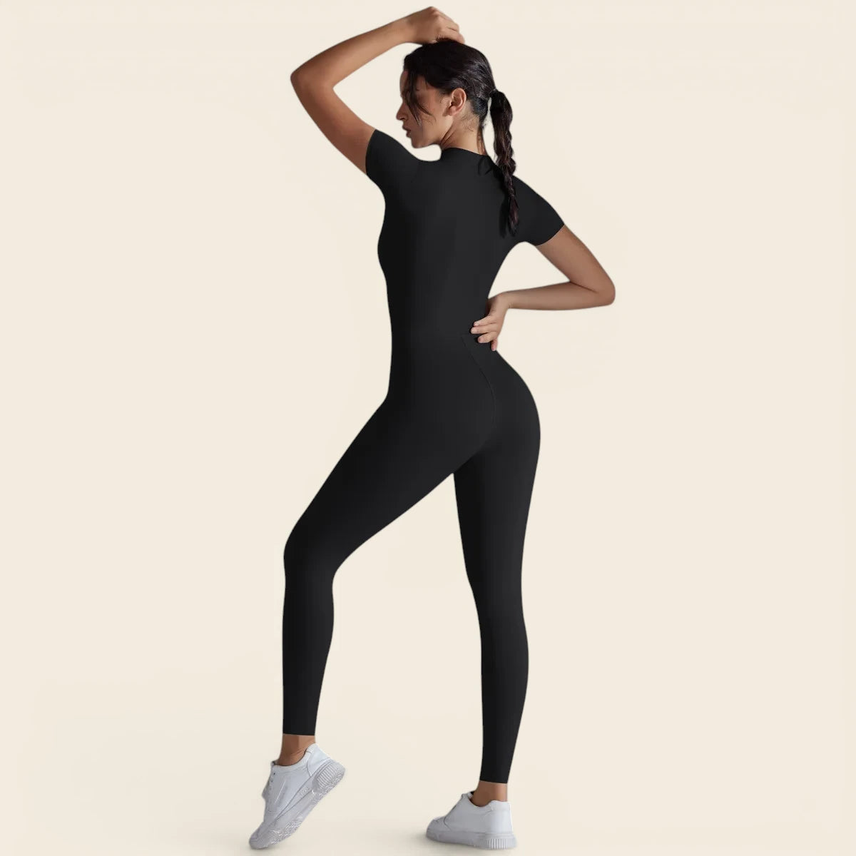 Combinaison de yoga noire pour femme portée en mouvement. Une liberté totale pour vos postures grâce à sa matière ultra-stretch.