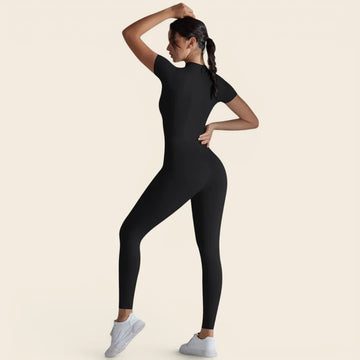 Combinaison de yoga noire pour femme portée en mouvement. Une liberté totale pour vos postures grâce à sa matière ultra-stretch.