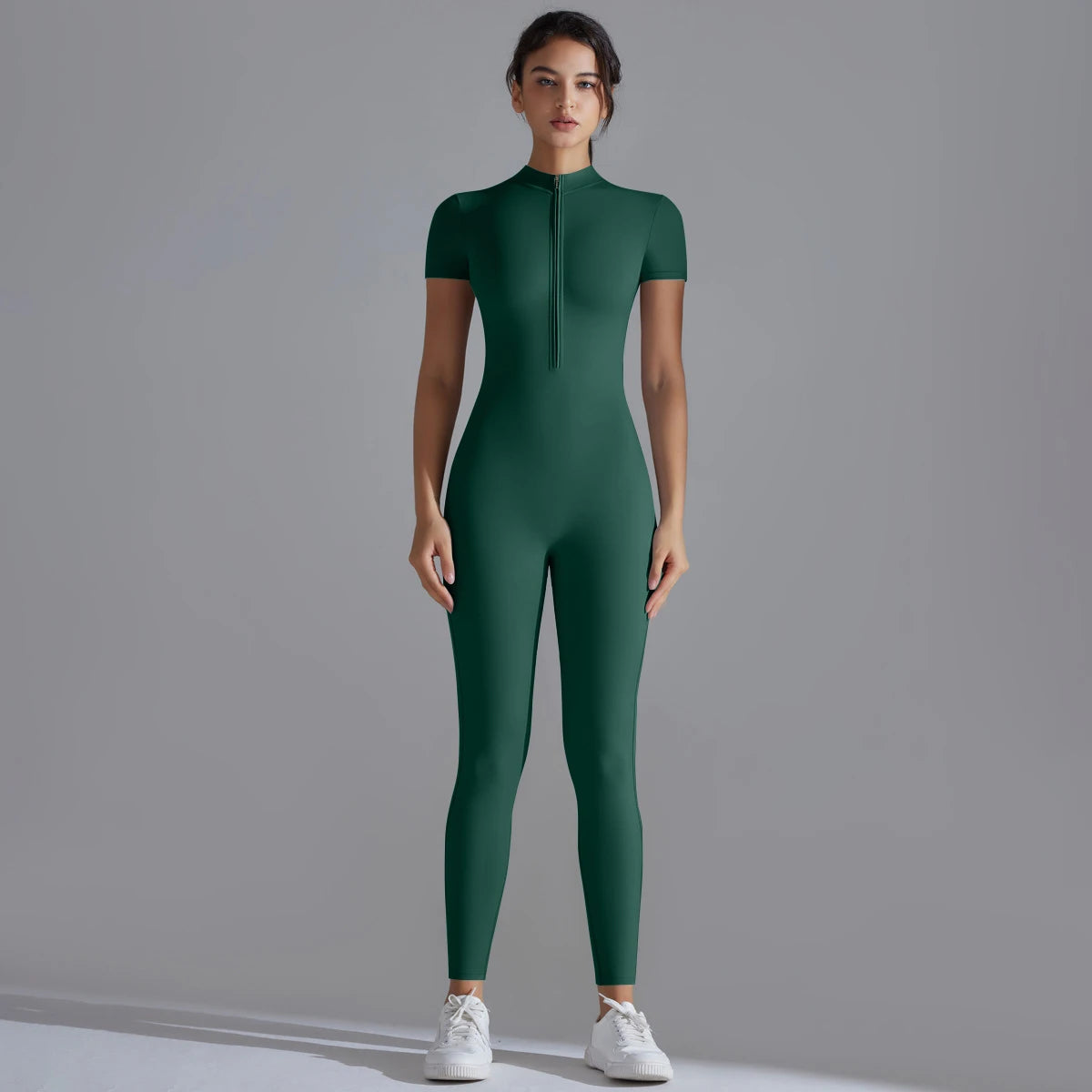 Combinaison yoga femme en vert sapin. Encolure avec zip frontal pour ajuster l'aération pendant l'effort.