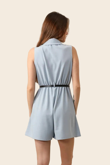 Dos d'une femme en combishort blazer bleu ciel avec ceinture contrastante nouée et short évasé à plis