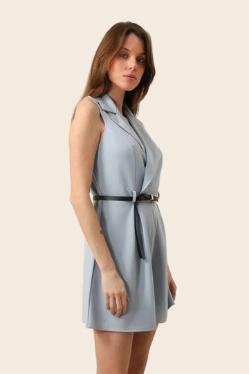 Vue de profil d'un combishort blazer bleu ciel col croisé, short fluide à plis, ceinture à nouer