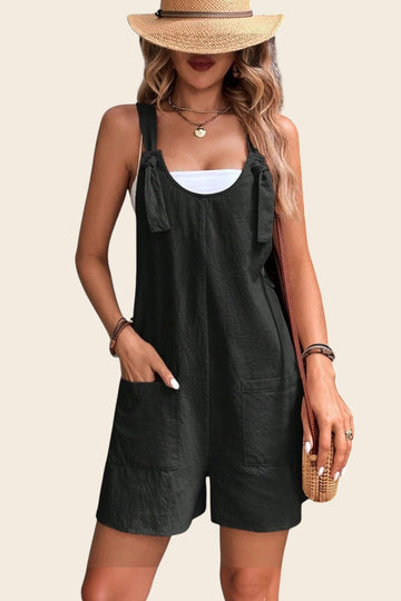 Combinaison short noire en polyester et élasthanne avec nœuds sur les bretelles et poches plaquées, par Maison de la Combi.