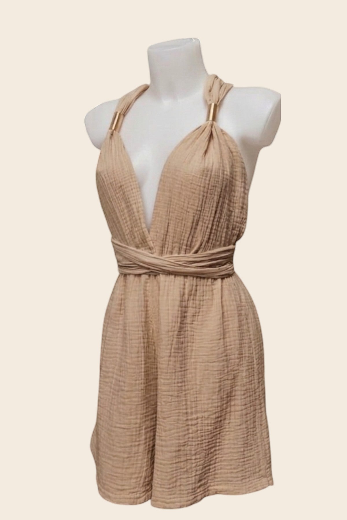 Détails de la coupe du combishort de plage beige La Bandolaise sur mannequin. Mise en valeur du tissu texturé et des petits anneaux dorés sur les bretelles par Maison de la Combi.