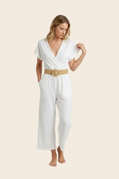 Femme portant la combinaison blanche La Sétoise de maison de la combi avec col V croisé et ceinture tressée