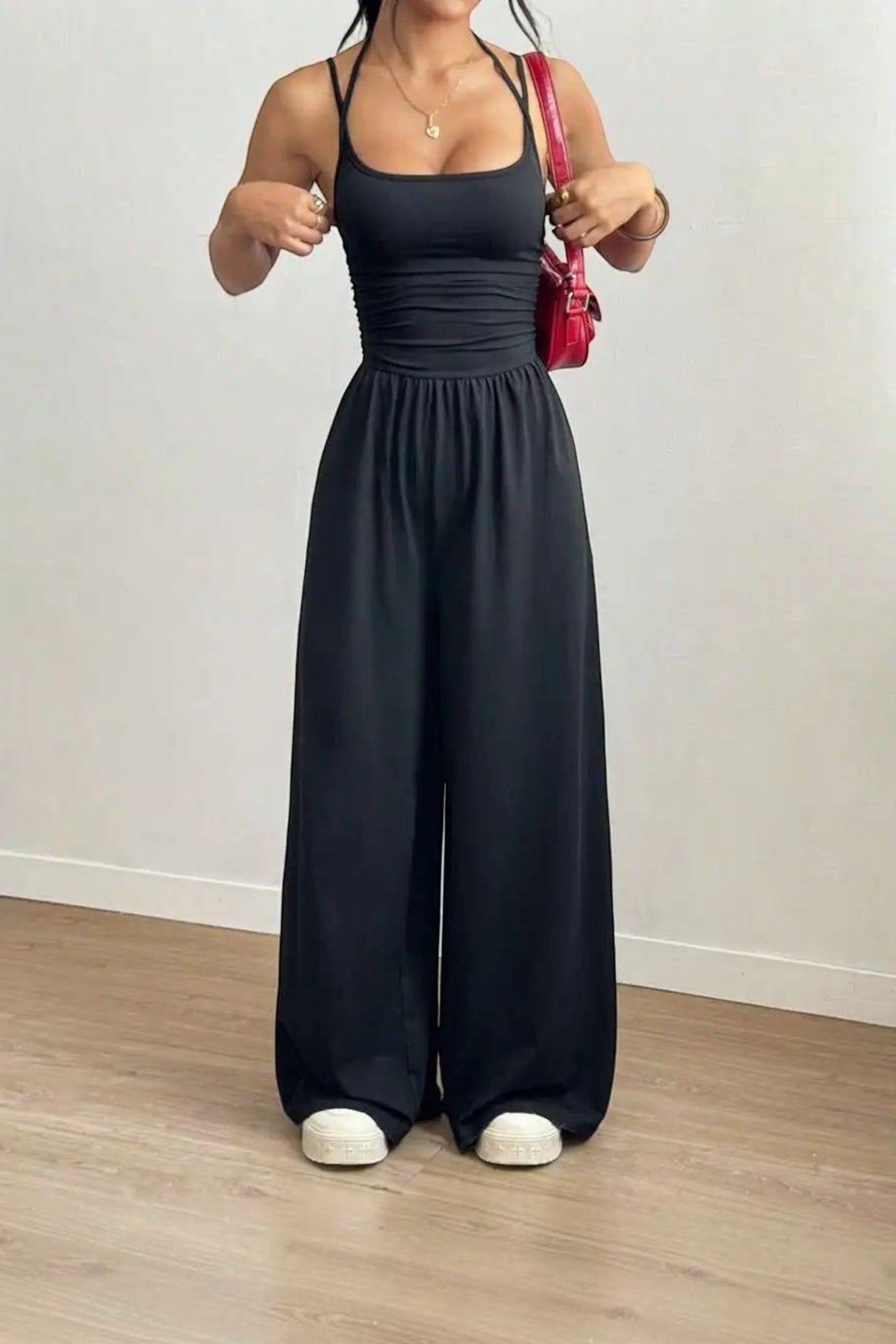 Combinaison noire dos nu chic La Esmeralda, bretelles fines, taille smockée, jambes larges, en polyester et élasthanne.