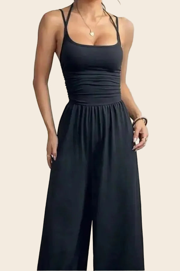 Combinaison noire dos nu chic La Esmeralda, bretelles fines, taille smockée, pantalon large, polyester et élasthanne.