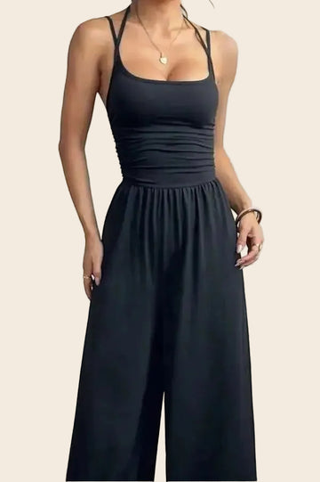 Combinaison noire dos nu chic La Esmeralda, bretelles fines, taille smockée, pantalon large, polyester et élasthanne.