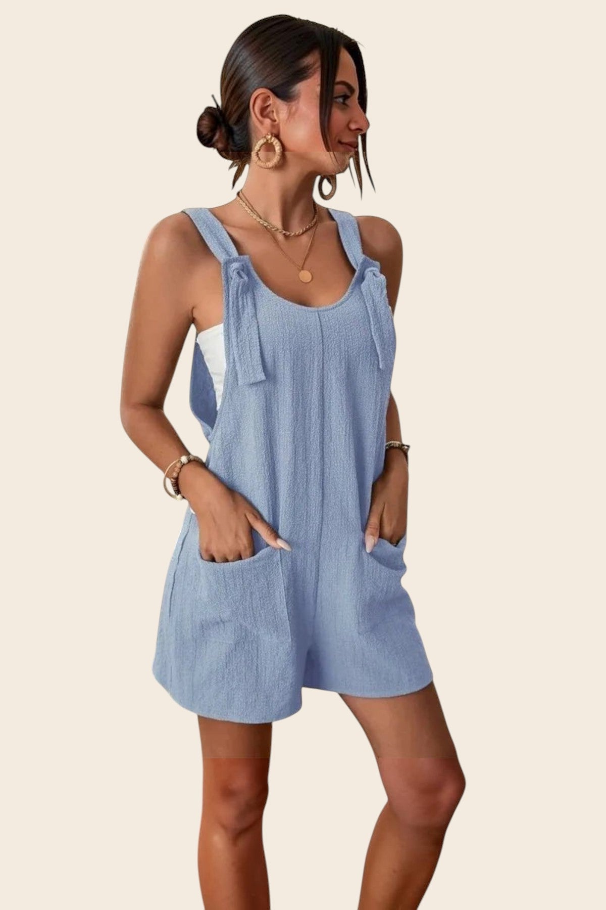 Combinaison short bleu ciel en polyester et élasthanne avec liens sur les bretelles et poches plaquées, par Maison de la Combi.