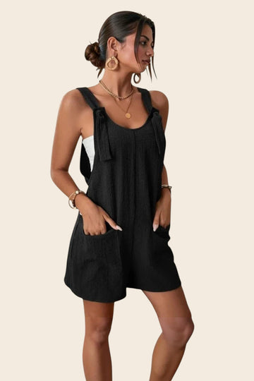 Combinaison short noire en polyester et élasthanne, avec liens sur les épaules et poches plaquées. Maison de la Combi.