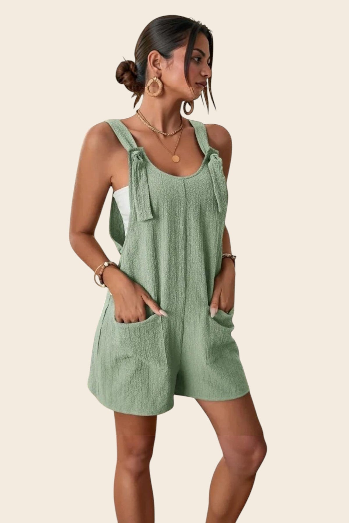 Combinaison short verte sauge en polyester et élasthanne, avec liens sur les épaules et poches plaquées. Maison de la Combi.