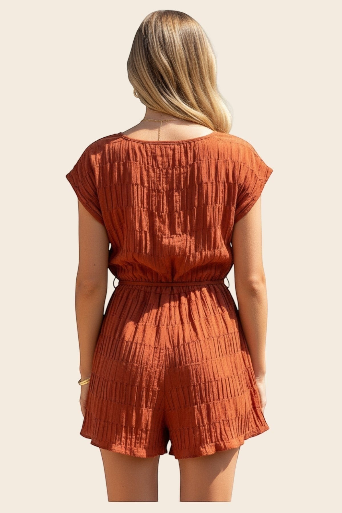 Vue arrière d'une femme portant le combishort terracotta Maison de la Combi en tissu plissé manches courtes 