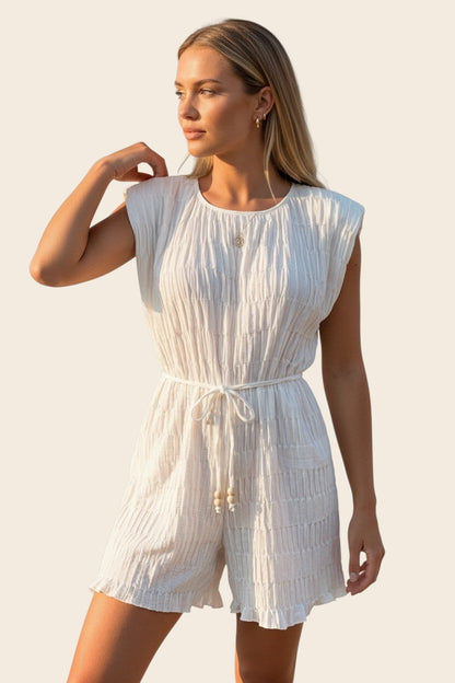 Tenue blanche estivale pour femme par Maison de la Combi. Le combishort La Malouine, idéal pour vos vacances ou un look de mariée décontracté.